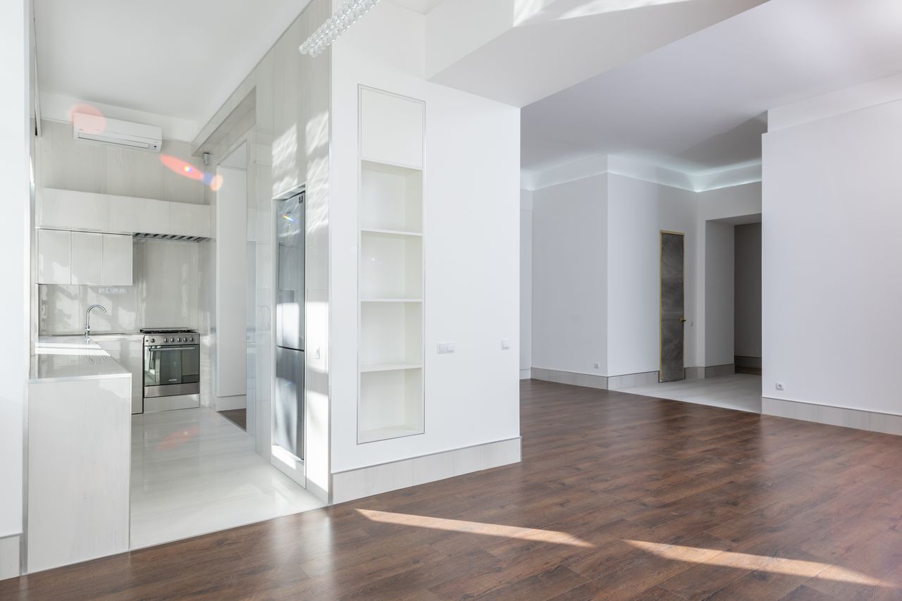 Intérieur moderne et spacieux avec cuisine ouverte et espace de vie, doté d’un élégant parquet en bois, idéal pour les habitations contemporaines.